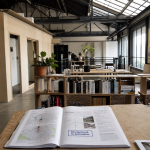 Intérieur d’un hangar aménagé en maison : loft avec poutres et baies vitrées