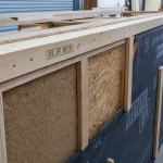Mur à ossature bois : montants, OSB et pare-pluie sur chantier